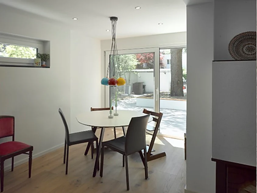 Essplatz mit rundem Tisch direkt am Kamin in einem Münchner Haus